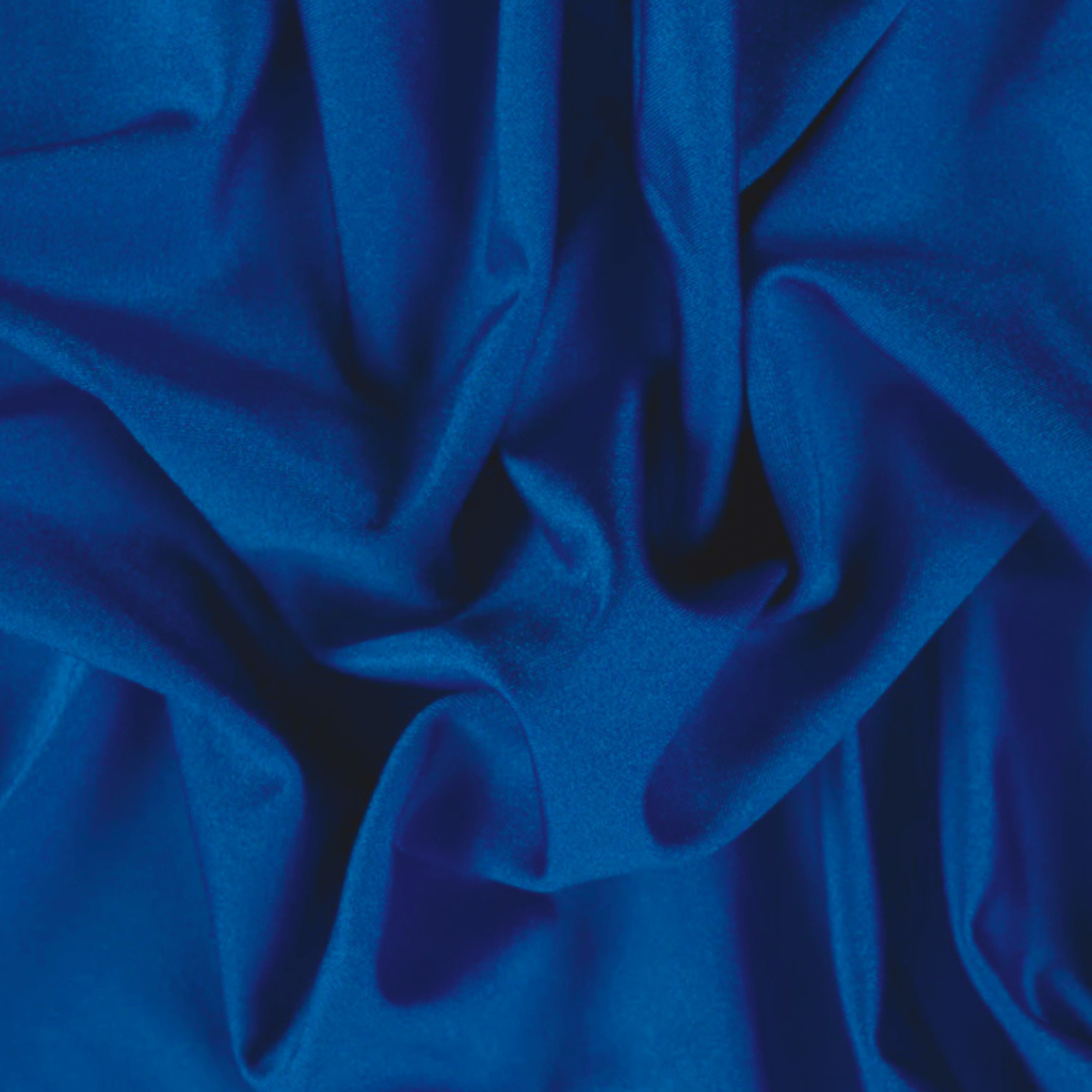 A close-up of draped royal blue fabric with soft folds and a smooth texture.