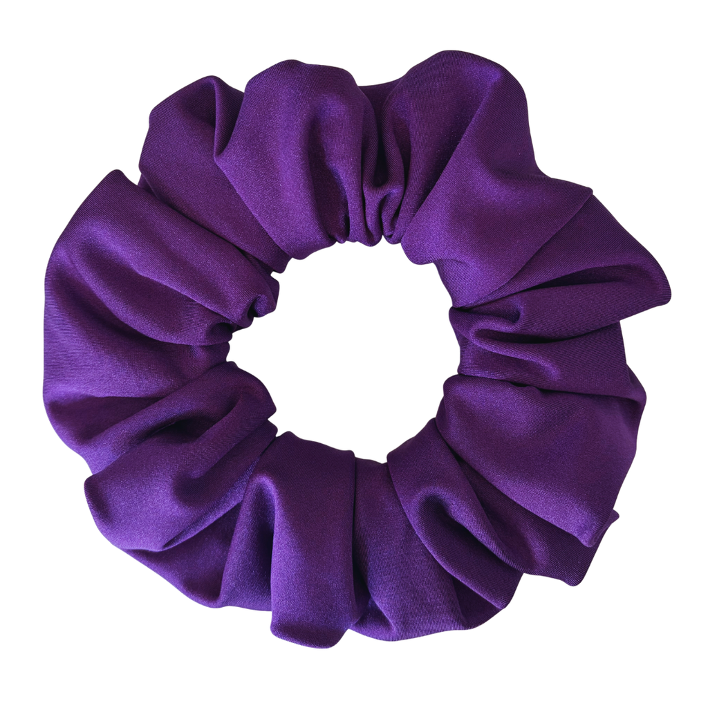 A single purple fabric scrunchie with a soft, gathered texture, shown against a plain white background.