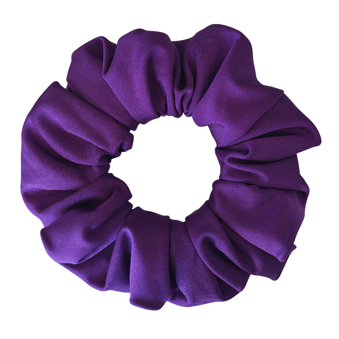 A single purple fabric scrunchie with a soft, gathered texture, shown against a plain white background.