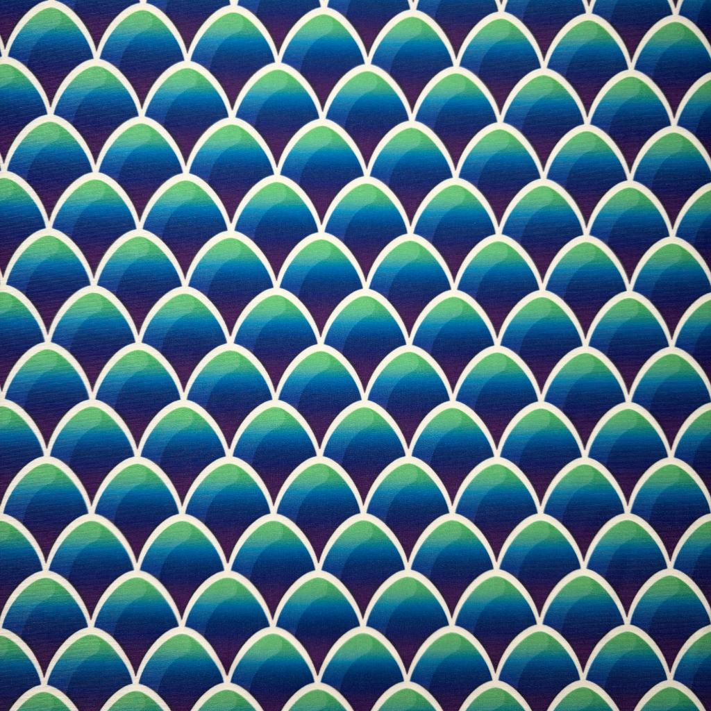 Pattern of blue and green mermaid scales on a dark blue background