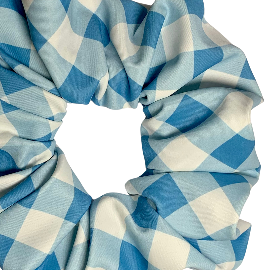 Close up of a blue and white checkered swim scrunchie on a white background