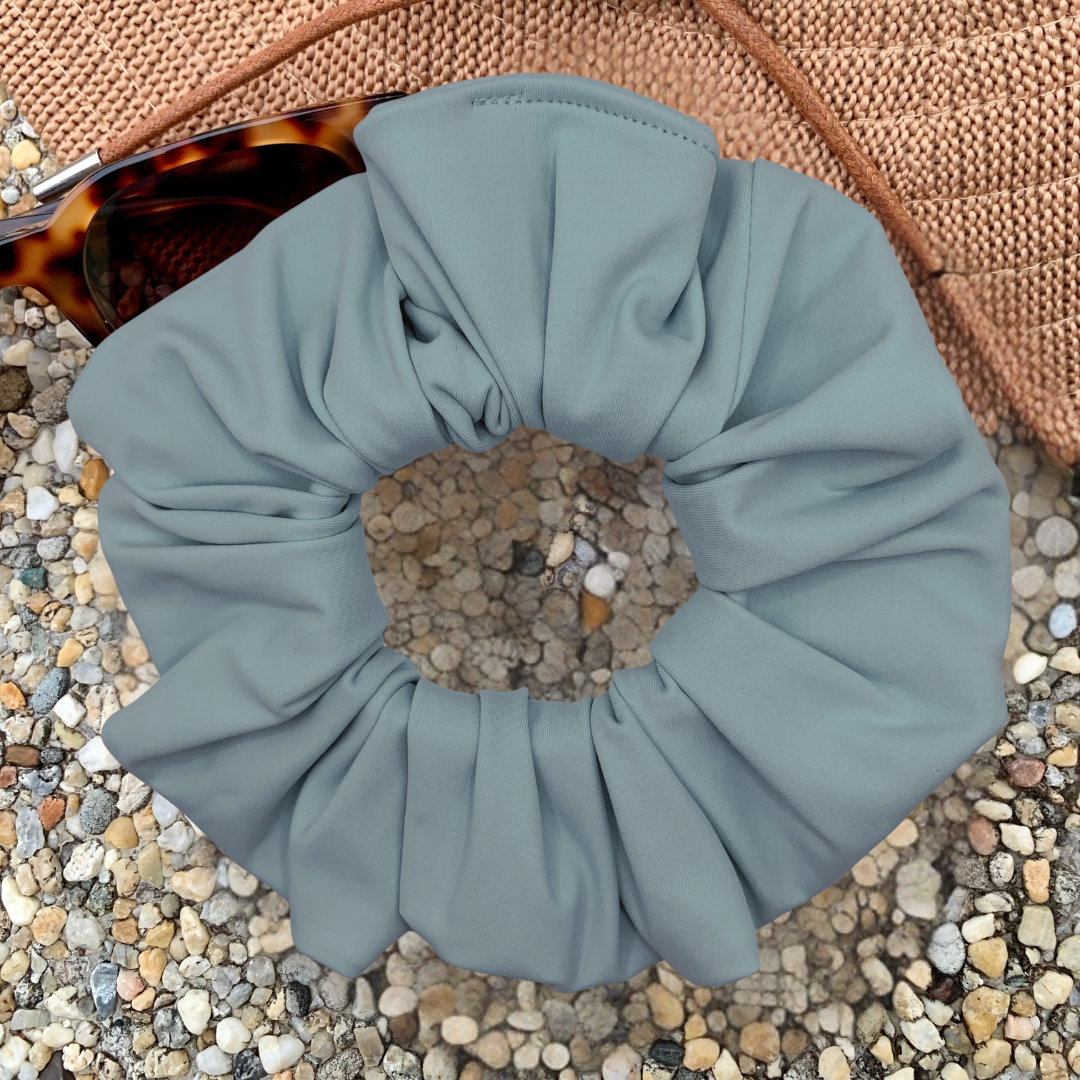 sky Blue scrunchie with pebbles on a textured surface