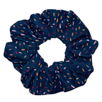 Navy blue scrunchie with multicoloured speckles on a white background