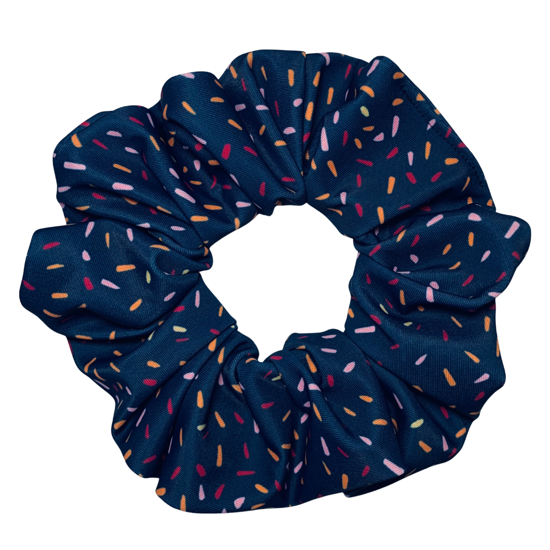 Navy blue scrunchie with multicoloured speckles on a white background