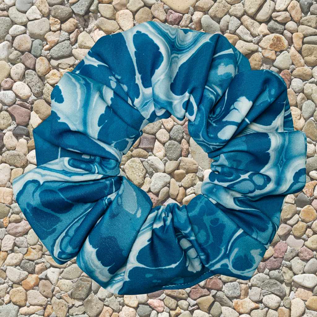 Blue and white patterned scrunchie on a stone surface