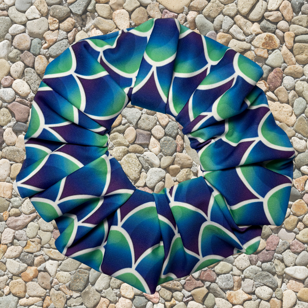 Blue and green mermaid patterned scrunchie on a stone surface