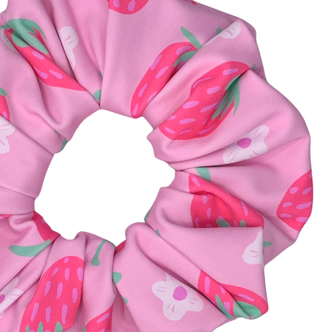 Pink scrunchie with strawberry pattern on a white background