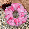 Pink scrunchie with strawberry pattern on a pebbly surface