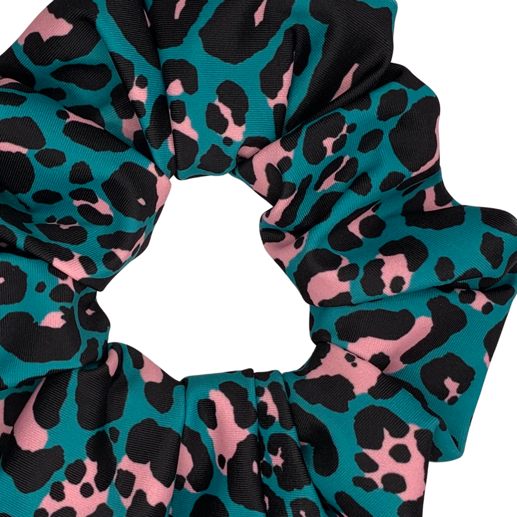 Teal, pink, and black leopard print scrunchie on a white background