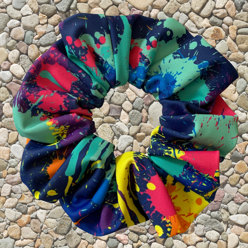 Colourful abstract swim scrunchie on a pebbled surface