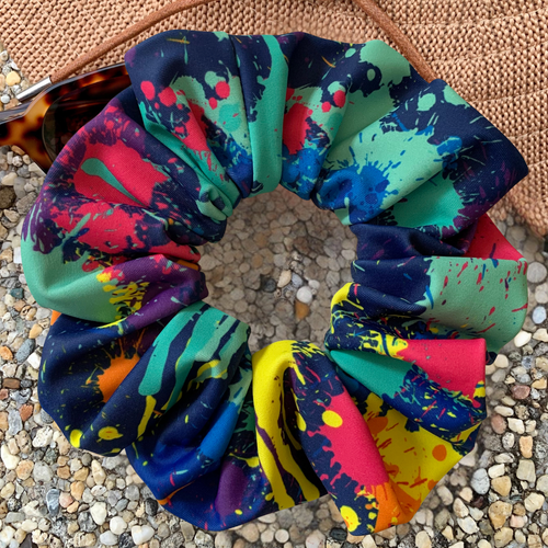 Colourful abstract swim scrunchie on a textured surface