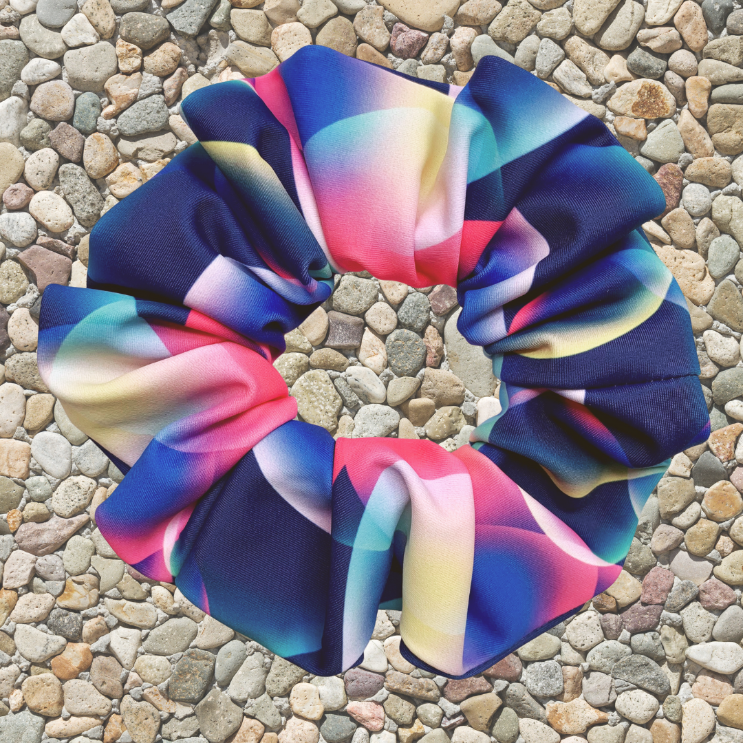 Neon bubble pattern swim scrunchie on a stone surface