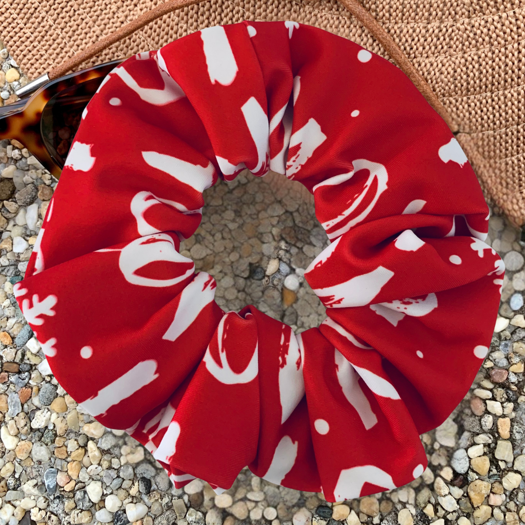 Christmas red and white ho ho ho swim scrunchie on a pebble surface