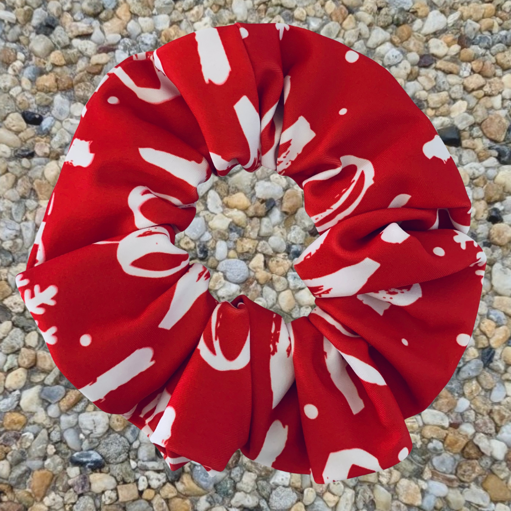 Christmas Red and white patterned ho ho ho swim scrunchie on a pebble surface