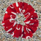 Christmas Red and white patterned ho ho ho swim scrunchie on a pebble surface