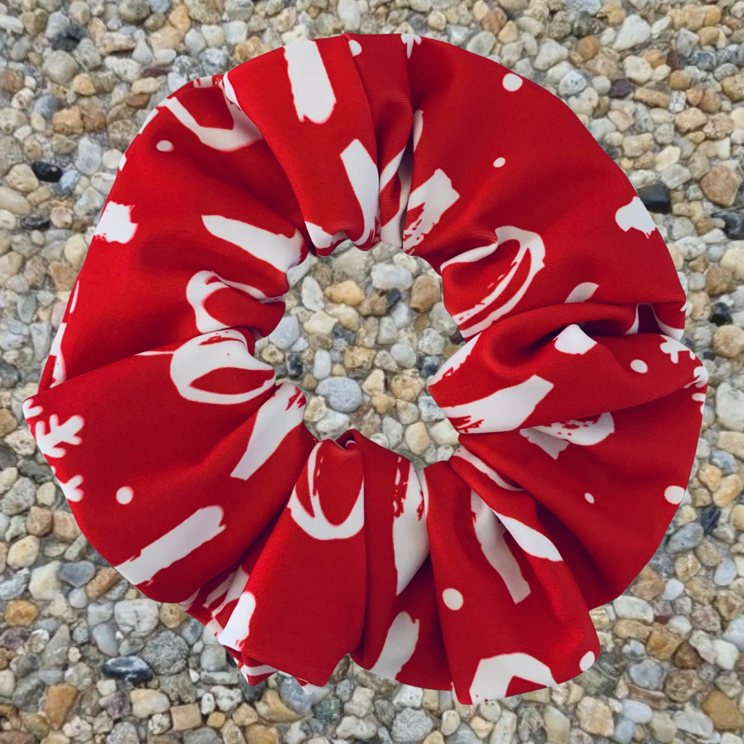 Christmas Red and white patterned ho ho ho swim scrunchie on a pebble surface