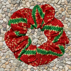 Red and green christmas swim scrunchie on a pebble surface