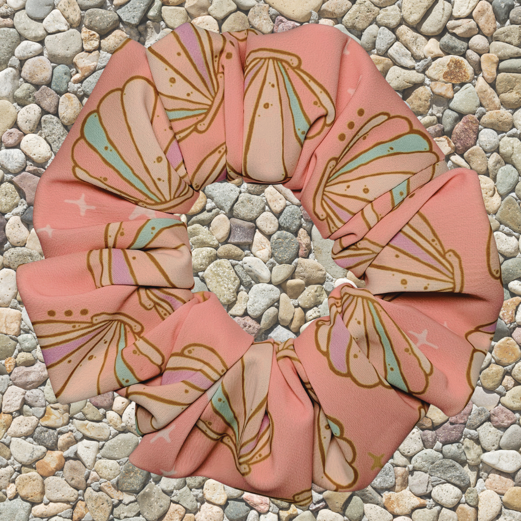 Pink seashell swim scrunchie on a pebble background