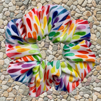 Colourful swim scrunchie on a pebbled surface