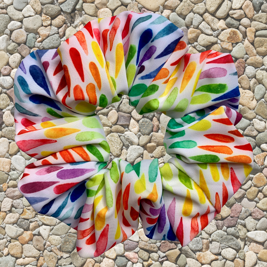 Colourful swim scrunchie on a pebbled surface