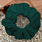 Emerald Green Swim Scrunchie on a textured surface with sunglasses and a hat