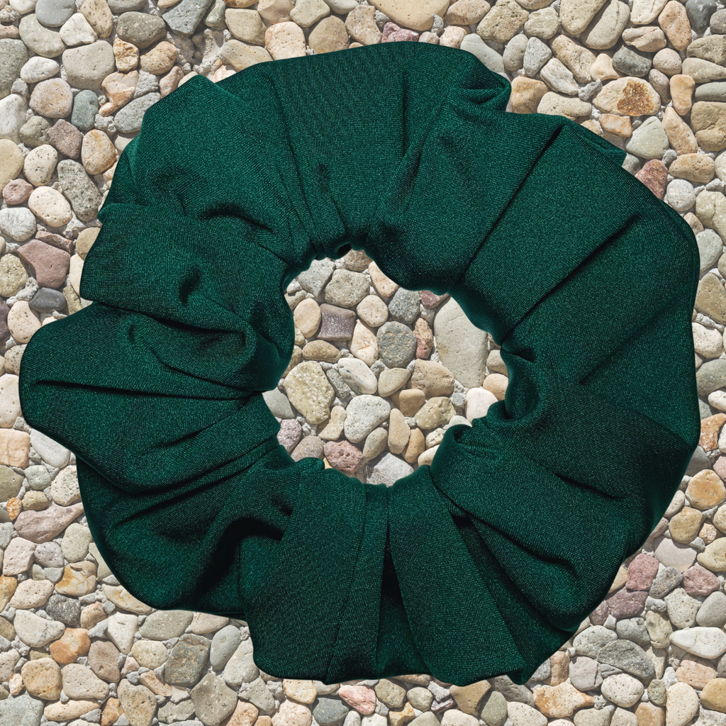 Emerald Green Swim Scrunchie on a stone surface