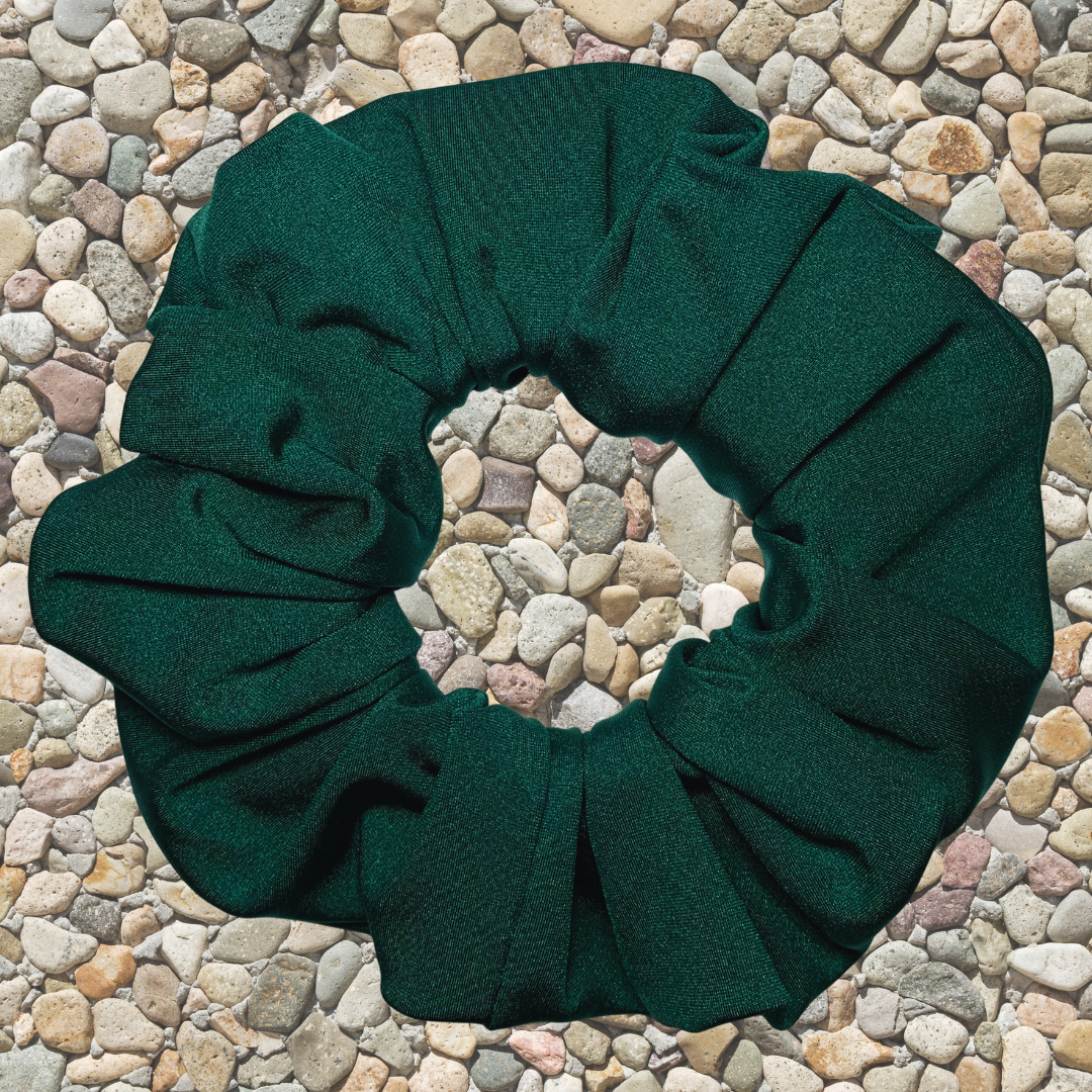 Emerald Green Swim Scrunchie on a stone surface