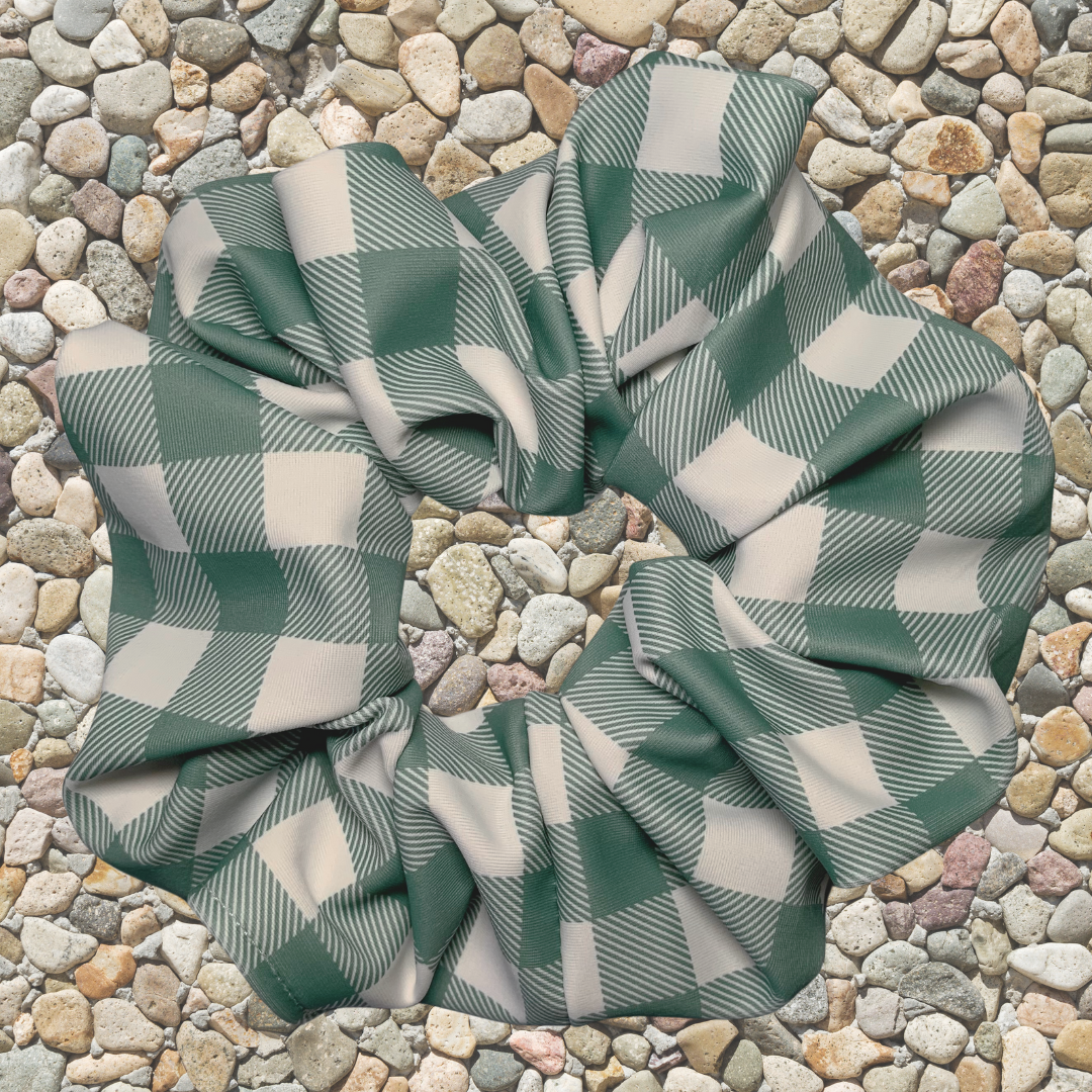 Green and white checkered swim scrunchie on a stone surface