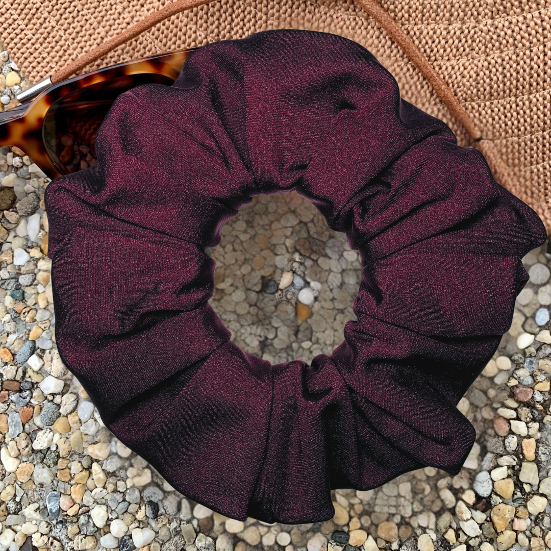 Rich merlot swim scrunchie sitting on hat and sunglasses