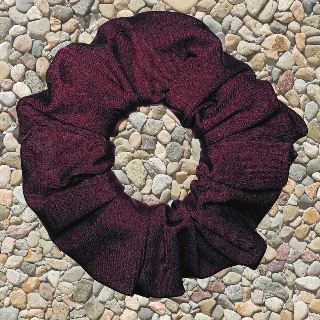 Rich merlot swim scrunchie on a pebble surface