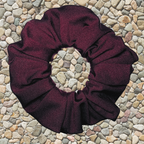 Rich merlot swim scrunchie on a pebble surface