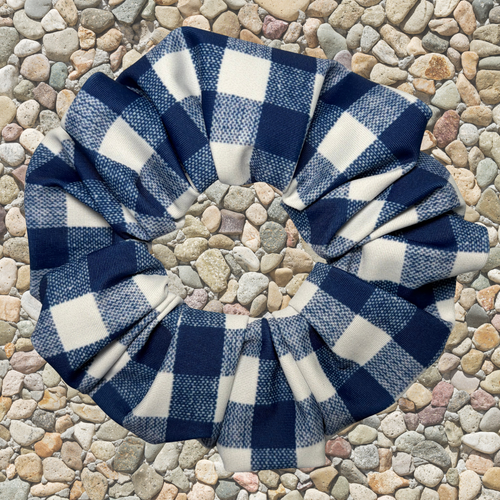 Blue and white checkered scrunchie on a pebble surface