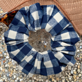 Blue and white checkered scrunchie on a textured surface