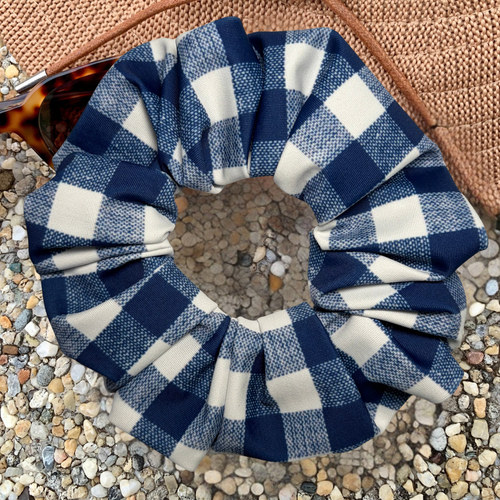 Blue and white checkered scrunchie on a textured surface