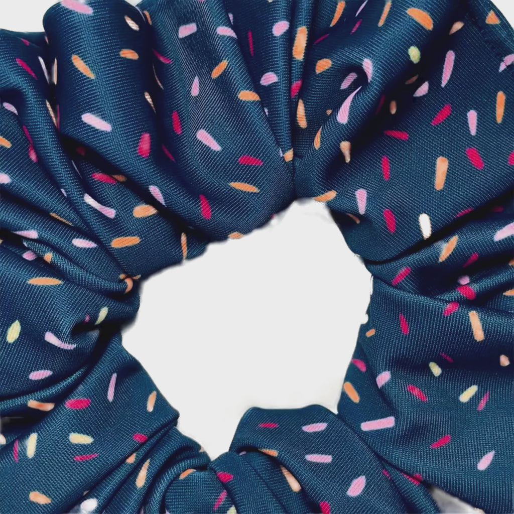 Navy blue scrunchie with multicoloured speckles on a white background video