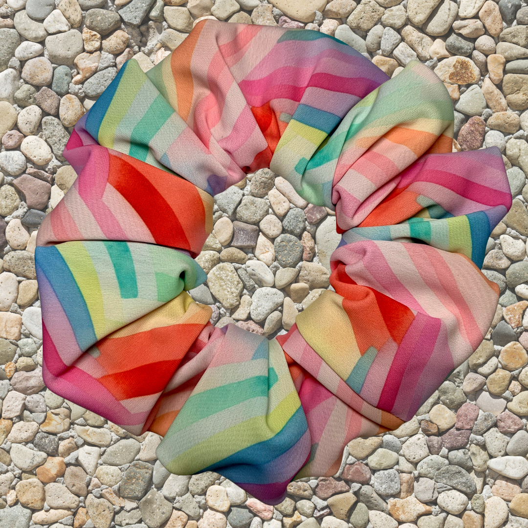 Colourful striped swim scrunchie on a pebble surface