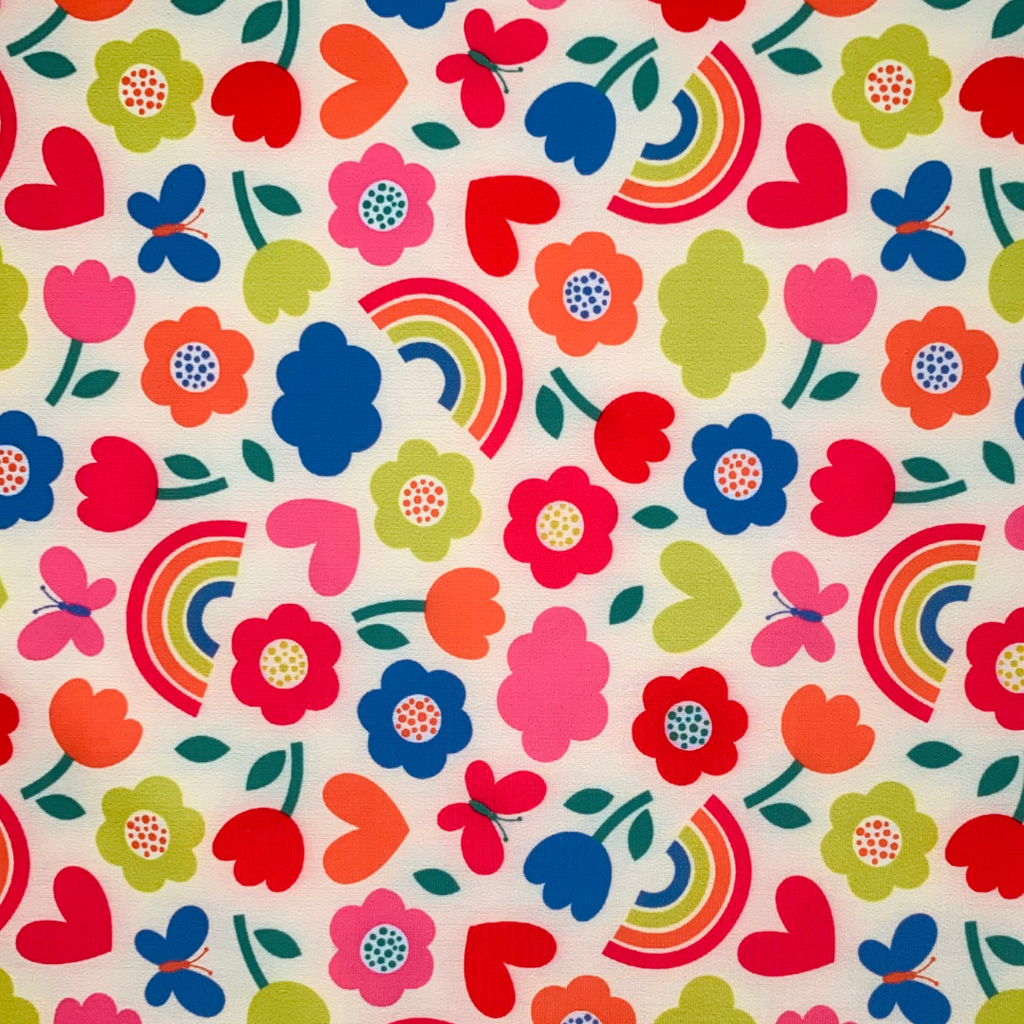 Colourful pattern of flowers, hearts, and rainbows on a white background
