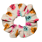 Swim scrunchie with colourful shell pattern on a white background