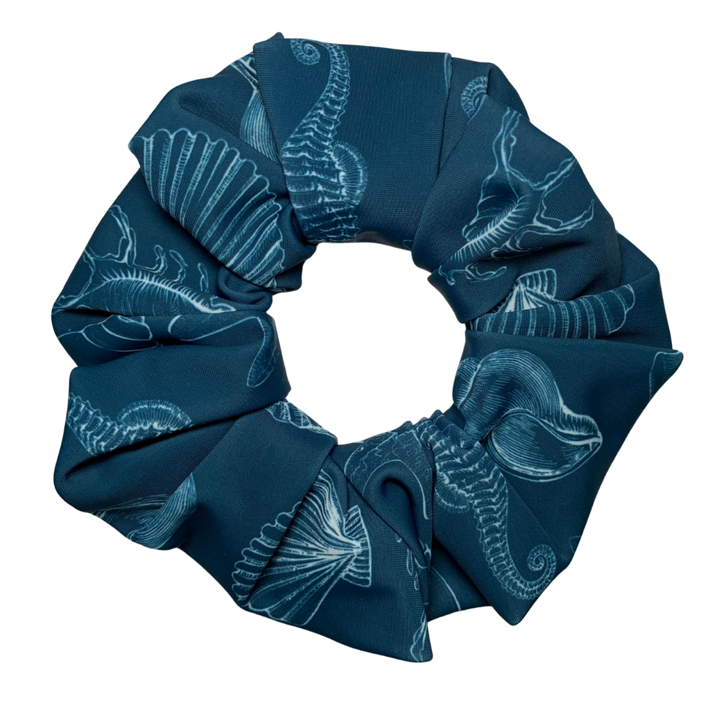 Blue swim scrunchie with white patterns of sea life and shells pattern on a white background