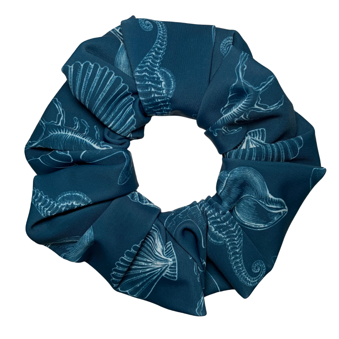 Blue swim scrunchie with white patterns of sea life and shells pattern on a white background