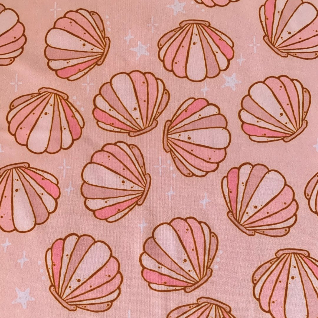Pink swim scrunchie with seashells on a pink background