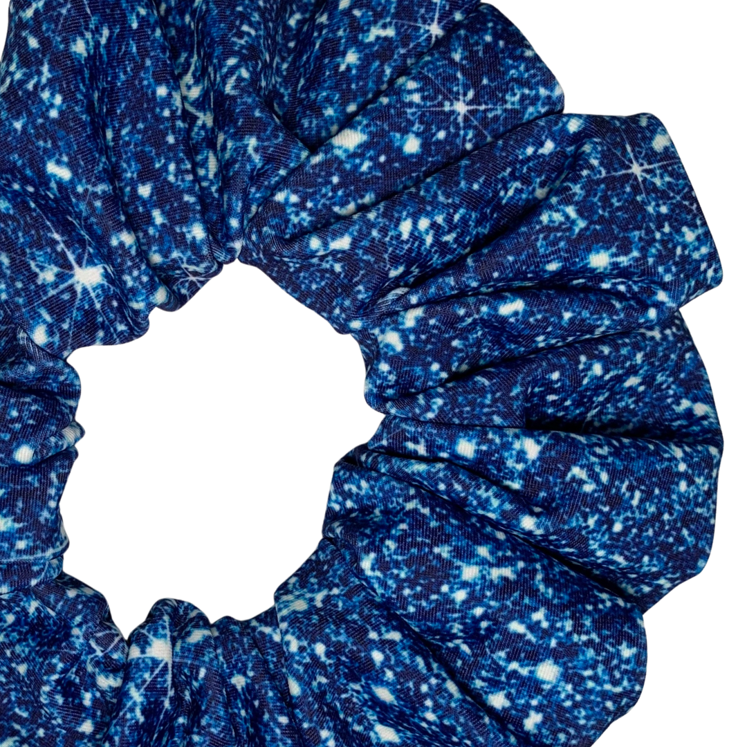 Close up of a Blue printed sparkle swim scrunchie on a white background