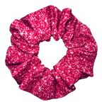 Close up of a Pink printed sparkle swim scrunchie on a white background