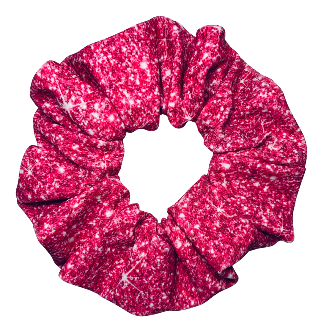 Close up of a Pink printed sparkle swim scrunchie on a white background