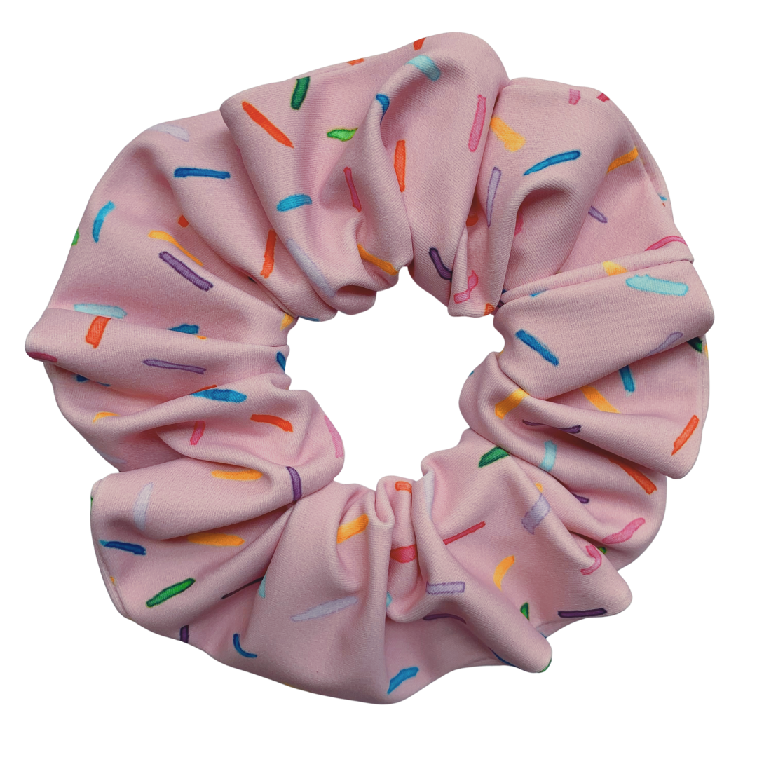 Pink swim scrunchie with colourful sprinkles on a white background