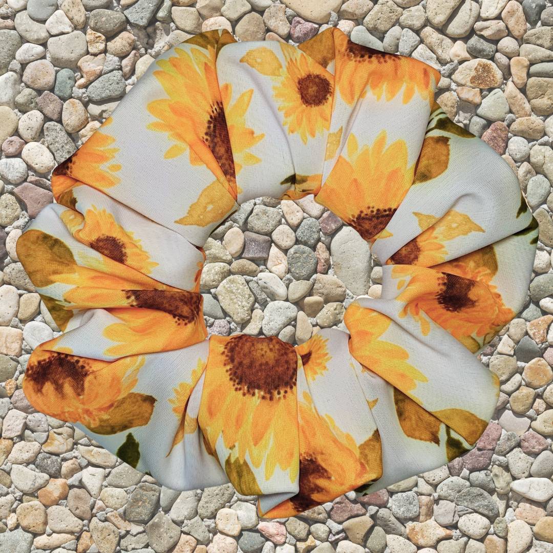 Sunflower patterned swim scrunchie on a stone surface